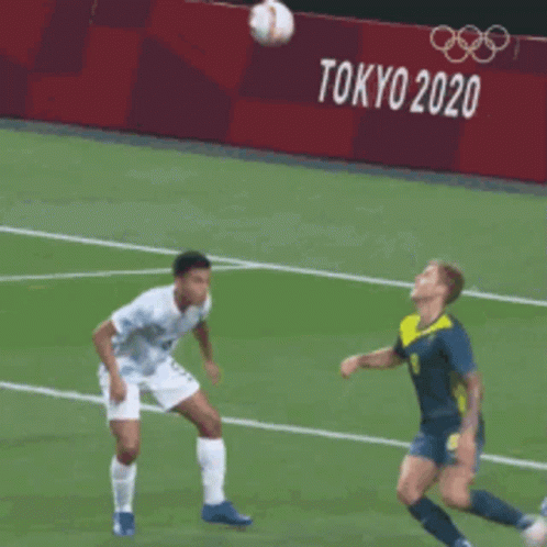 Soccer Players On A Field With A Tokyo 2020 Sign Behind Them GIF