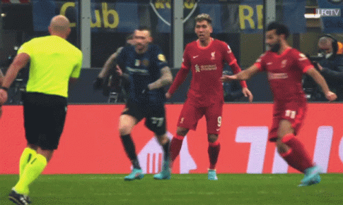Soccer Players On A Field With A Yellow Referee And A Sign That Says Club GIF