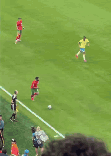 soccer players on a field with one wearing a red jersey with the number 11 on it