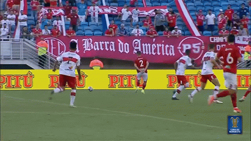 Soccer Players on Field With Barra do America Banner