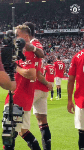 Soccer Players on Field With Sir Alex 26 Years Sign