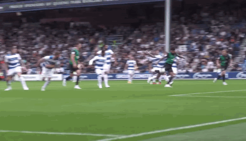 Soccer Players Playing on Field With Sponsors of Queens Park Sign