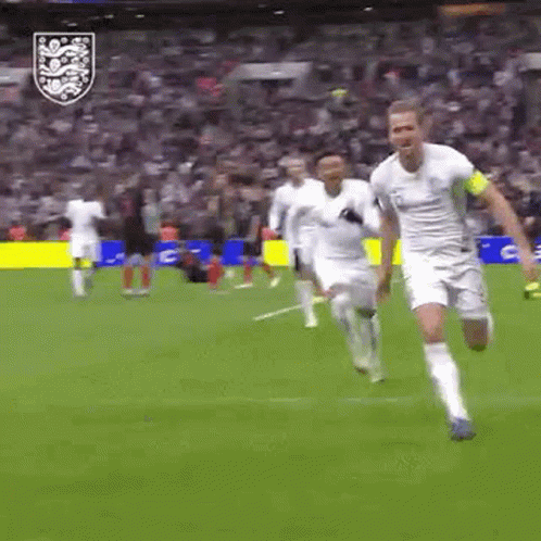 Soccer Players Running in Front of Crowd