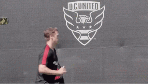 Soccer Players Running in Front of D.C. United Logo
