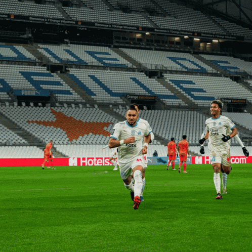 Soccer Players Running On A Field With Uber Eats Written On Their Jerseys GIF