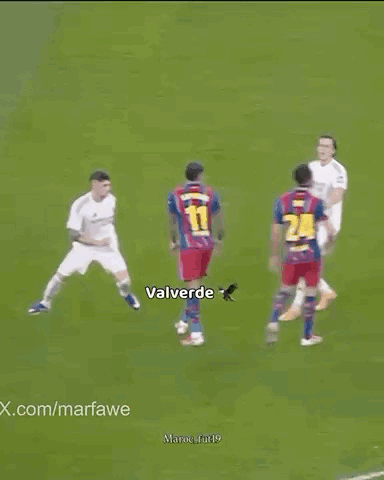 Soccer Players Standing Around Player Lying on Field