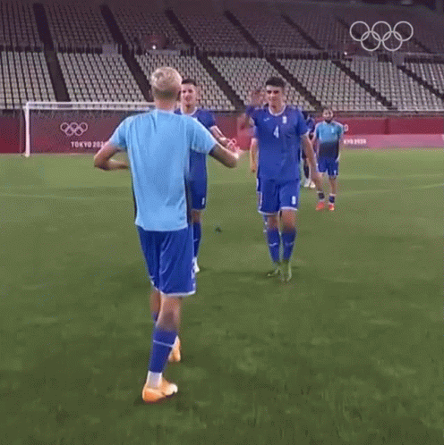 Soccer Players Standing On Field In Front Of Stadium GIF