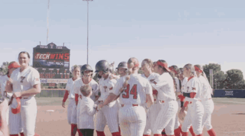 Softball Players in Front of Tech Wins Sign