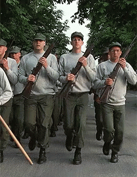 Soldiers Marching Down Street Holding Guns