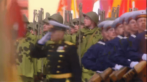 Soldiers Marching in Line with Man in Black Uniform