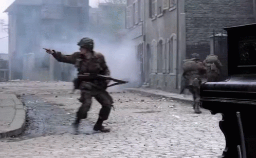 Soldiers Walking and Pointing on Cobblestone Street
