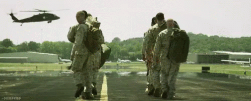 Soldiers Walking On Runway With Helicopter GIF