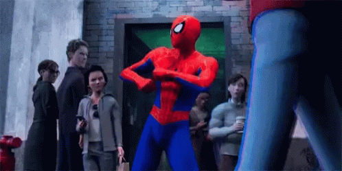 Spider-Man Is Flexing His Muscles In Front Of A Group Of People In A Crowd . GIF