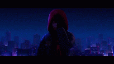 spider-man is standing in front of a city at night .