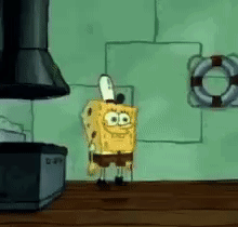 Spongebob Squarepants Is Standing On A Wooden Table In Front Of A Stove . GIF