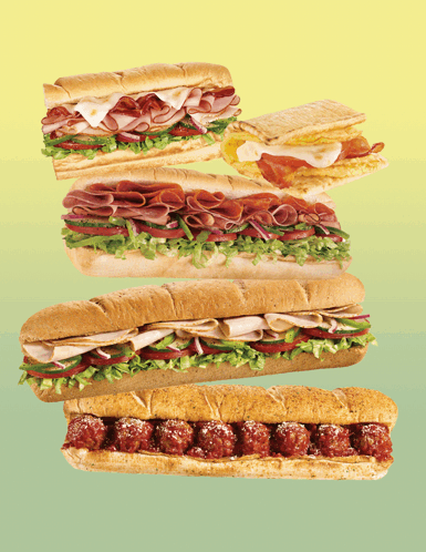 Stacked Sub Sandwiches On Green And Yellow GIF