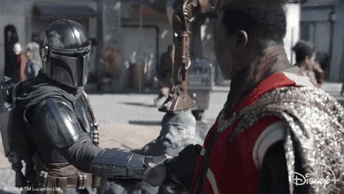 Star Wars Man in Red Vest Shaking Hands With Helmeted Man