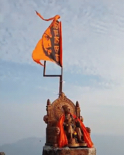 Statue Of Man Sitting On Throne With Flag GIF