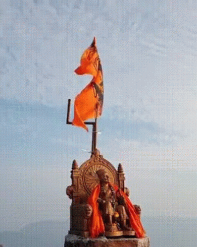 Statue of Man Sitting on Throne With Orange Flag