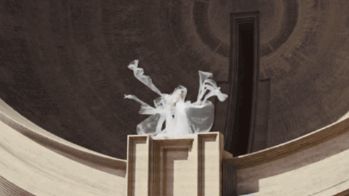 Statue of Woman in White Dress in Front of Building With Letter I