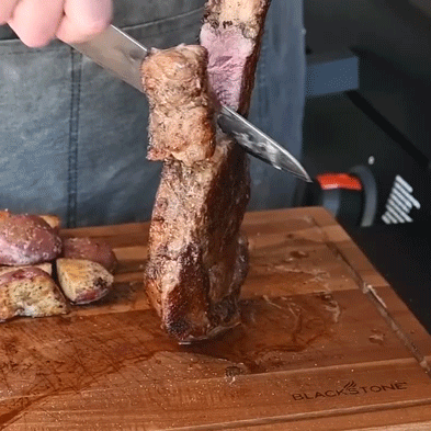 Steak Being Cut on Blackstone Board