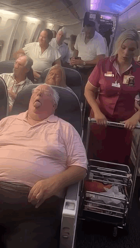 Stewardess Pushing Cart With Sleeping Man