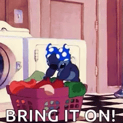 Stitch From Disney 'S Lilo And Stitch Is Sitting In A Laundry Basket Full Of Clothes . GIF