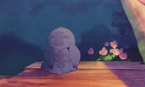 Stitch Sitting on Wooden Table Eyes Closed