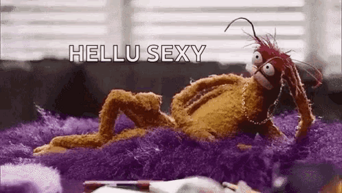 Stuffed Animal Laying On Purple Blanket On Couch GIF