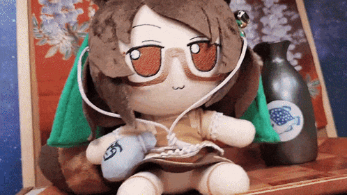 Stuffed Animal With Glasses and Headphones Next to Vase