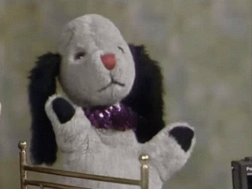 Stuffed Animal With Purple Bow Tie Sitting in Chair