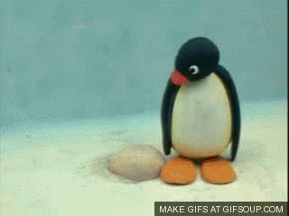 Stuffed Penguin Standing on Rock