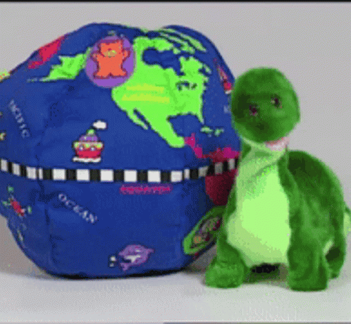 Stuffed Turtle Next to Blue Globe Saying Ocean