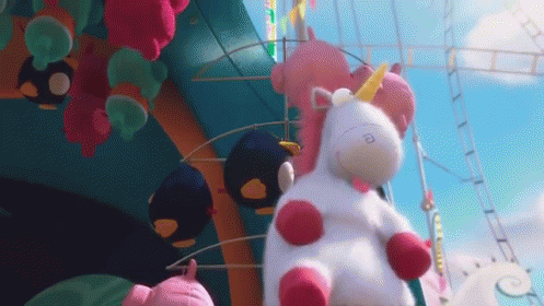 Stuffed Unicorn Sitting in Front of Roller Coaster