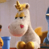 Stuffed Unicorn With Yellow Horn Sitting Beside Another Stuffed Animal