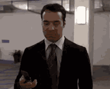 Suit and Tie Man Holding Phone Walking