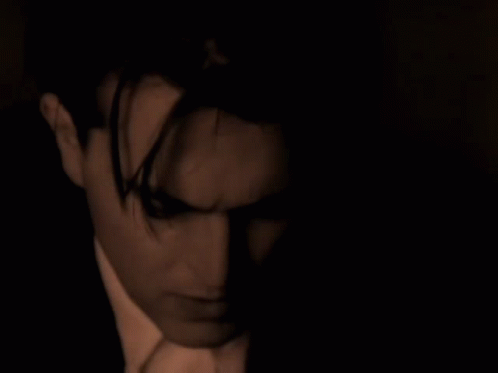 Suit-and-Tie Man Looking at Camera in Dark Room