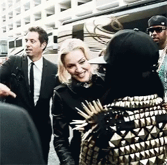 Suited Man Talking to Woman in Spiked Jacket