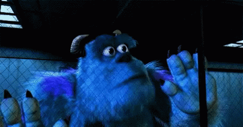 Sulley From Monsters Inc Is Standing In A Dark Room With His Hands Outstretched . GIF
