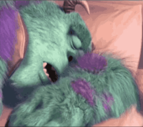 Sulley From Monsters Inc Laying On A Bed With His Mouth Open GIF