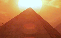 Sun Setting Behind Pyramids In Desert GIF