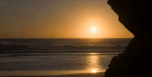 Sun Setting Over Ocean Waves GIF