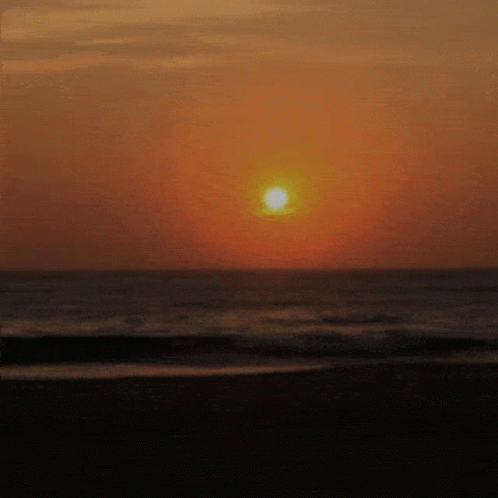 Sun Setting Over Ocean Waves GIF