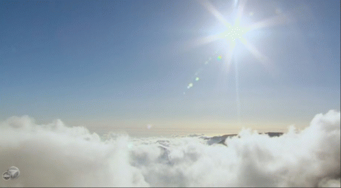 Sun Shining Over Clouds and Mountains