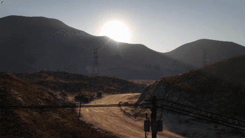 Sun Shining Over Mountains and Power Lines