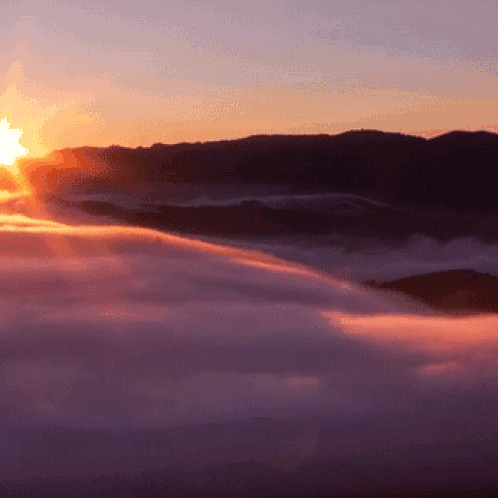 Sun Shining Through Clouds in Mountains