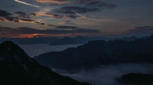 Sunset Over Mountain Range With Plane Flying