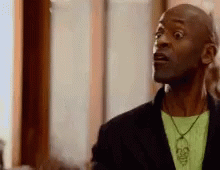 Surprised Man with Black Jacket Green Shirt Skull Necklace