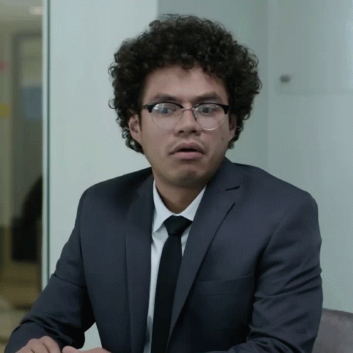 Surprised Man With Curly Hair And Glasses In Suit GIF