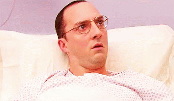 Surprised Man With Glasses Lying in Hospital Bed